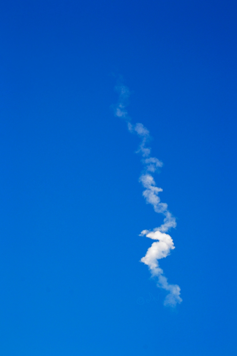 SpaceX Falcon midday rocket launch over hillside