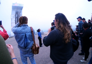 Erect rocket amidst fog, crowd photographing