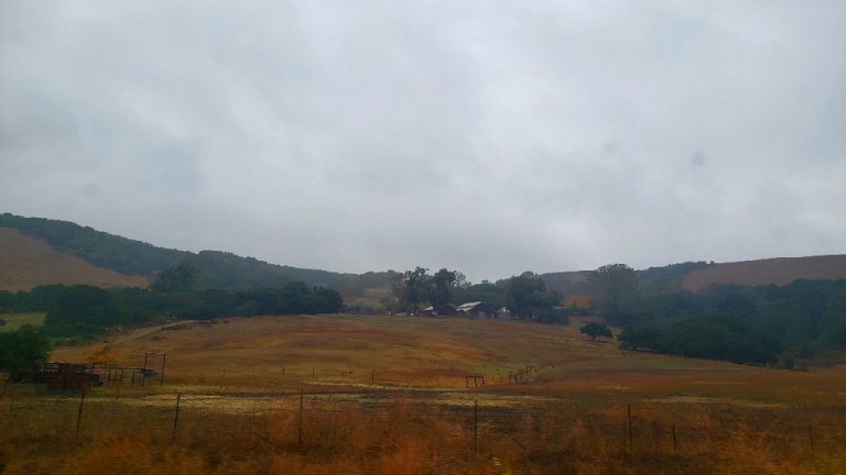 Barn on reddish brown hill, gray sky